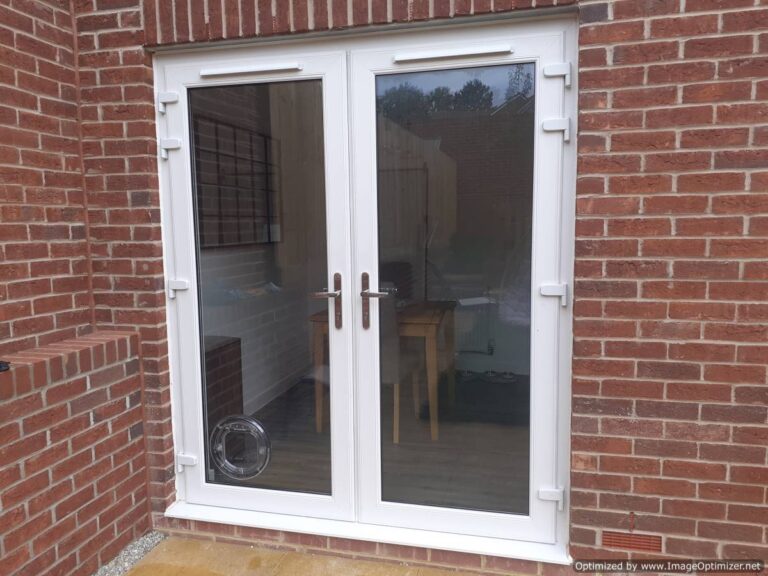 A Pet-Tek Maxi-Dual Glaze Clear Cat Flap installed in the corner position of a double-glazed french door